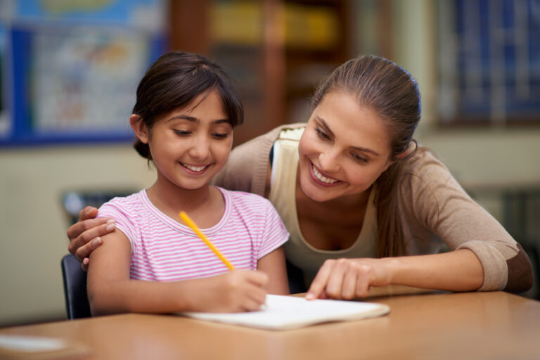 teacher helping student write and read